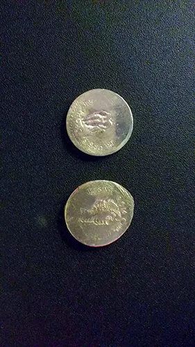 Dos reproducciones de moneda romana sobre fondo oscuro, del taller de acuñación