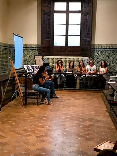 Sala con paneles expositivos y público asistiendo a una actividad didáctica